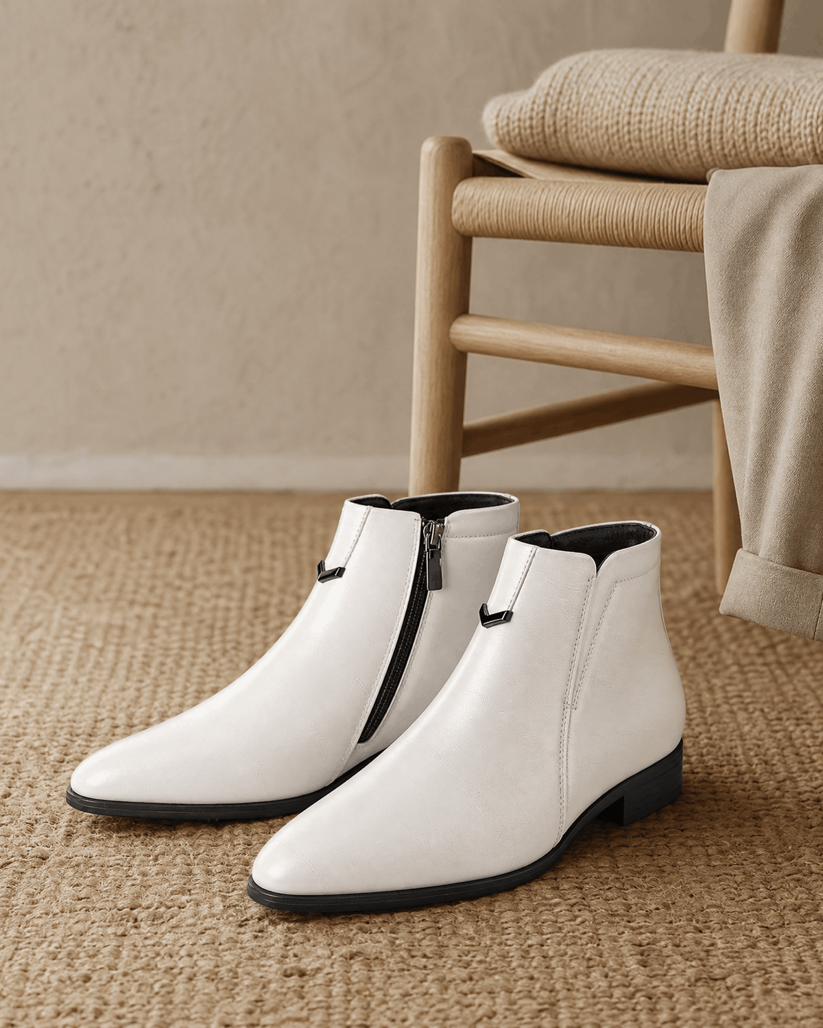 White polished grain ankle boots with a pointed toe, side zip closure, and notched topline on a textured carpet.