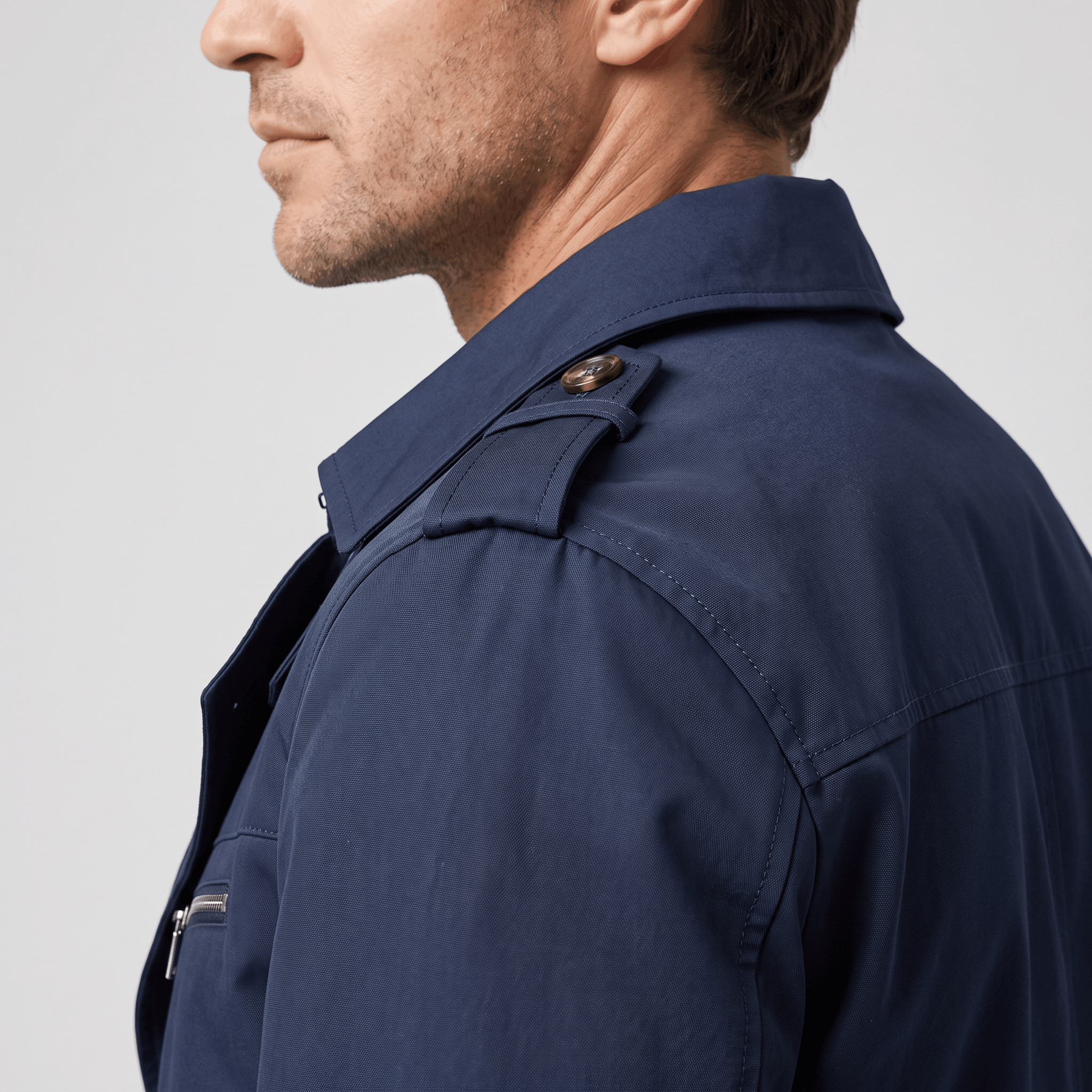 Side view of the navy blue trench coat showing the collar and shoulder epaulettes.