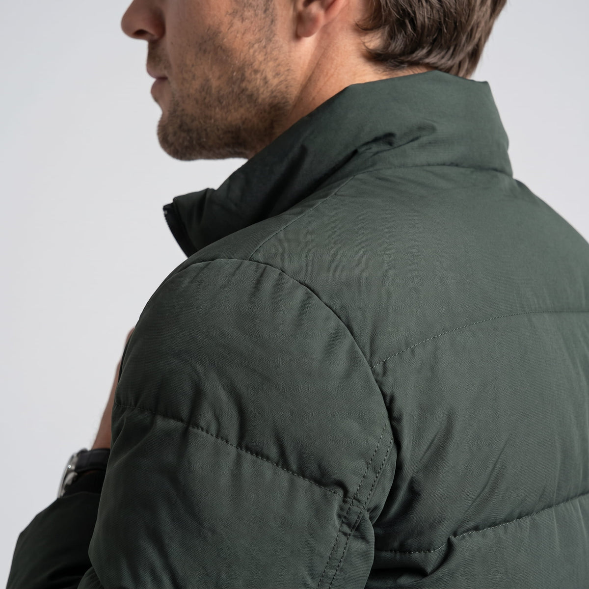 Dark green shoulder detail with matte shell fabric and raised collar seam