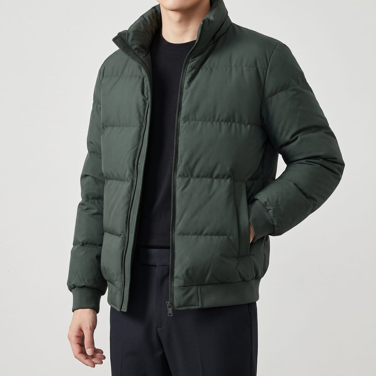 Dark green jacket over a black crewneck, quilted panels across the chest