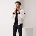 Man wearing white stand-collar puffer bomber jacket, unzipped over a black top