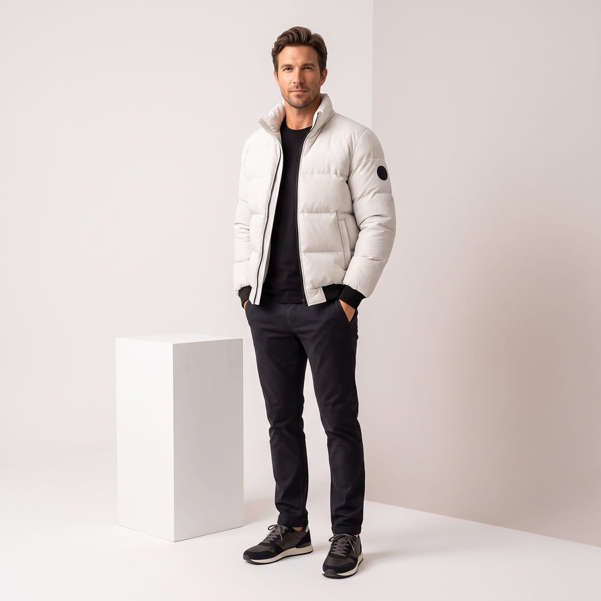 White jacket styled full-length with dark jeans and black leather sneakers