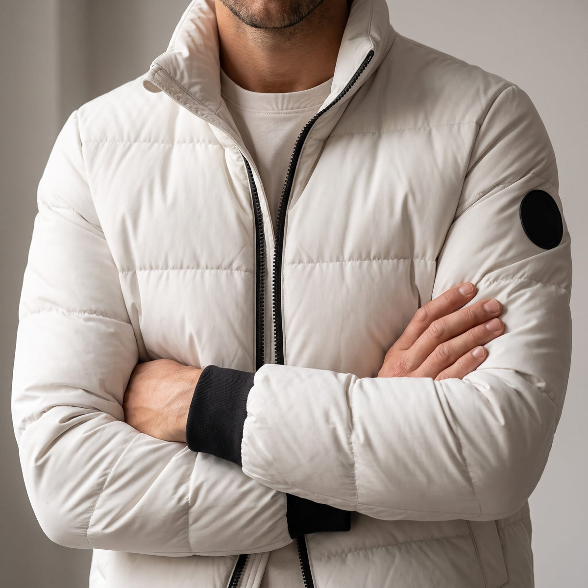 Close torso view in white showing boxy quilting, sleeve patch and black ribbed cuffs