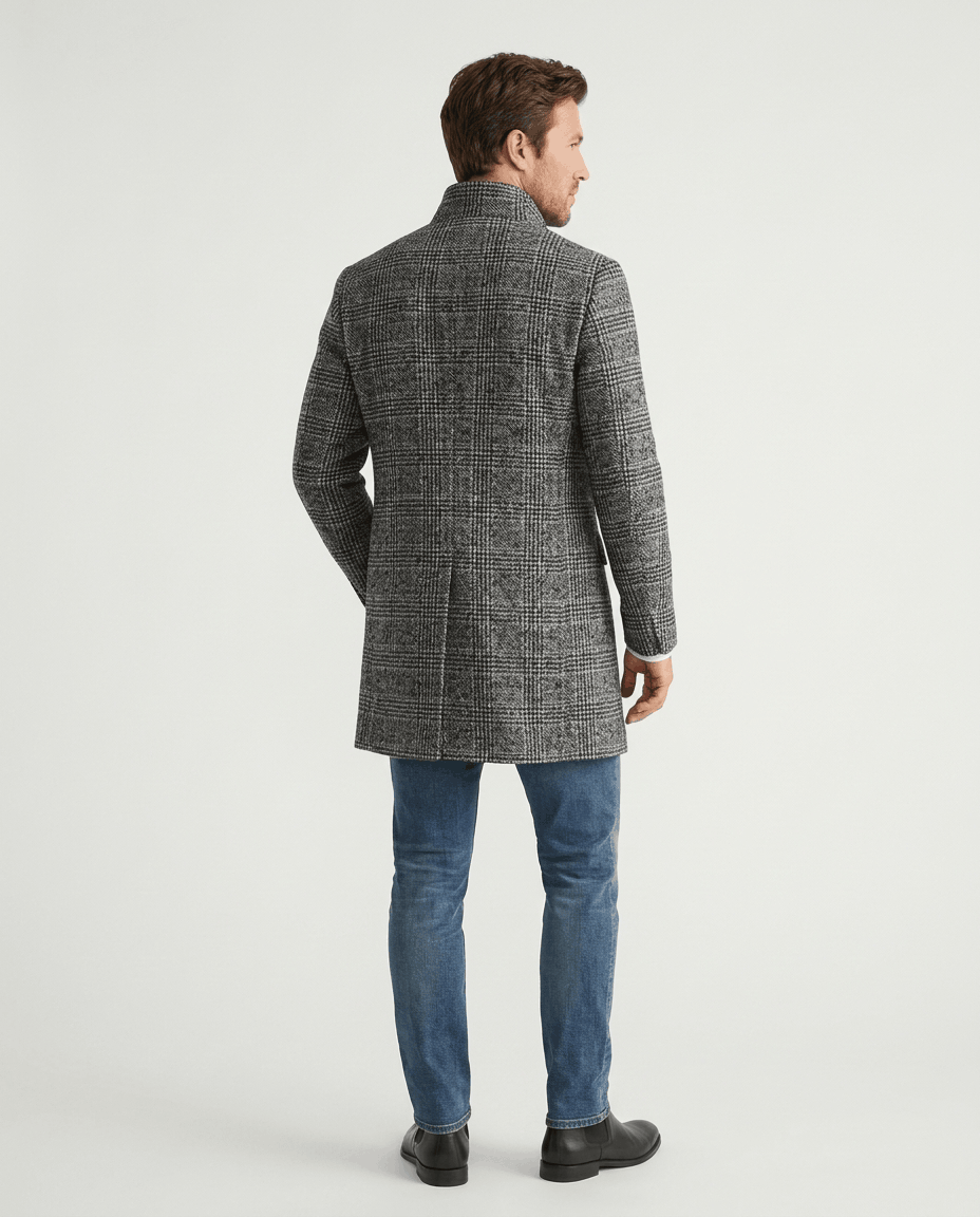 Back view of the light gray and black herringbone overcoat worn with blue jeans
