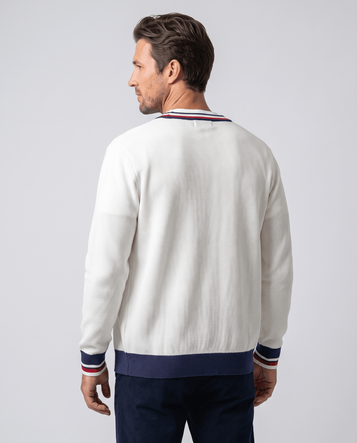 Back view of the cream white cardigan with navy ribbed hem and striped cuffs