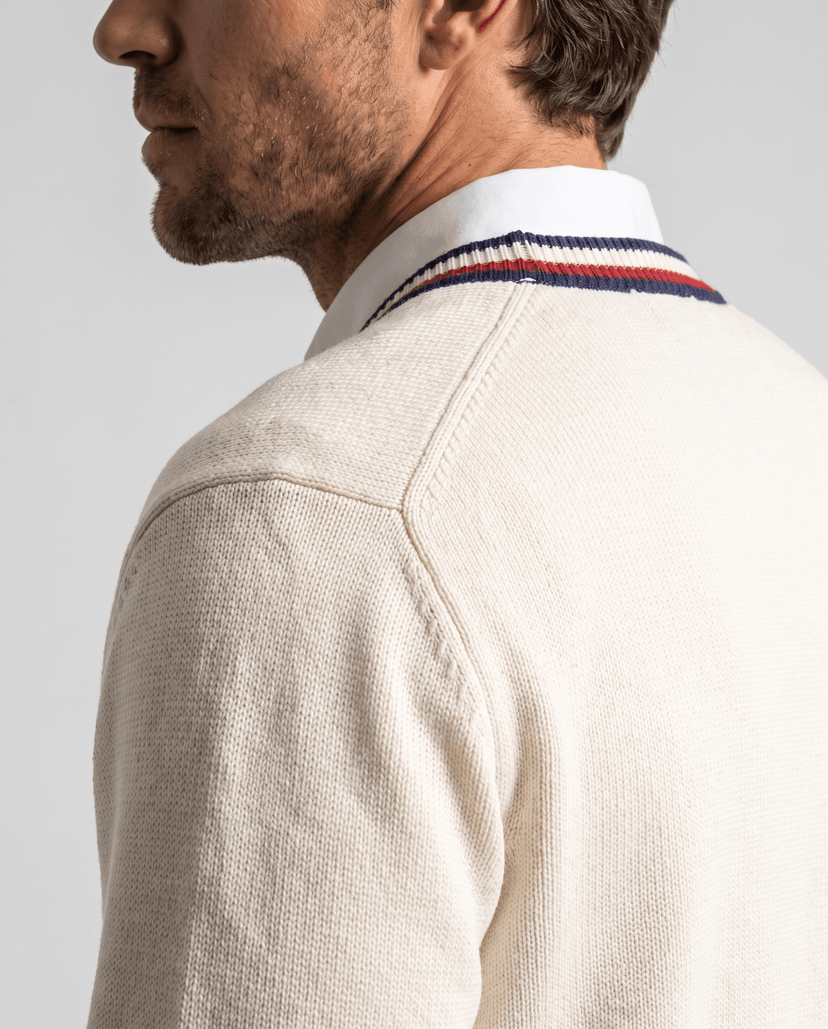 Side close-up of the cream fine knit and striped trim at the shoulder