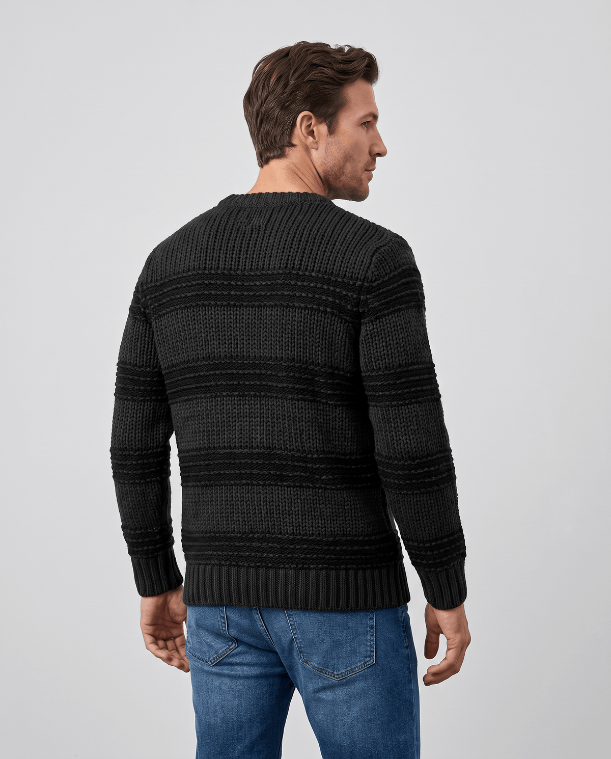 Back view of black striped crew neck sweater with ribbed cuffs