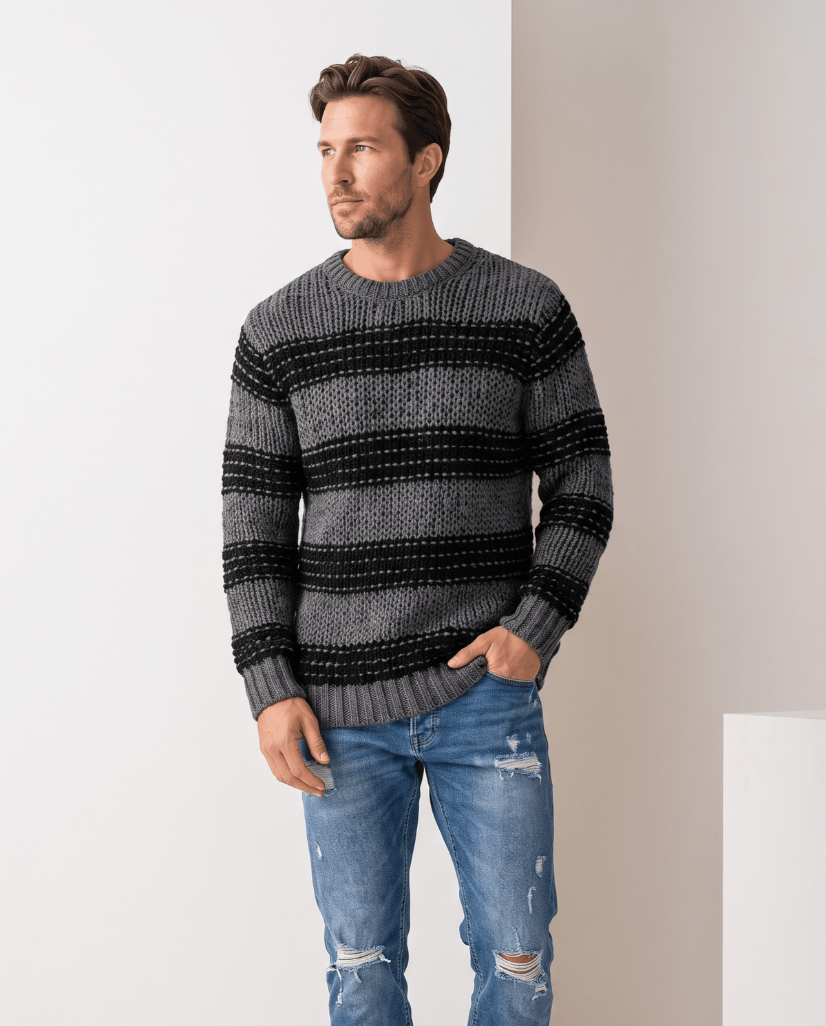 Model in black striped chunky knit sweater with ripped blue jeans