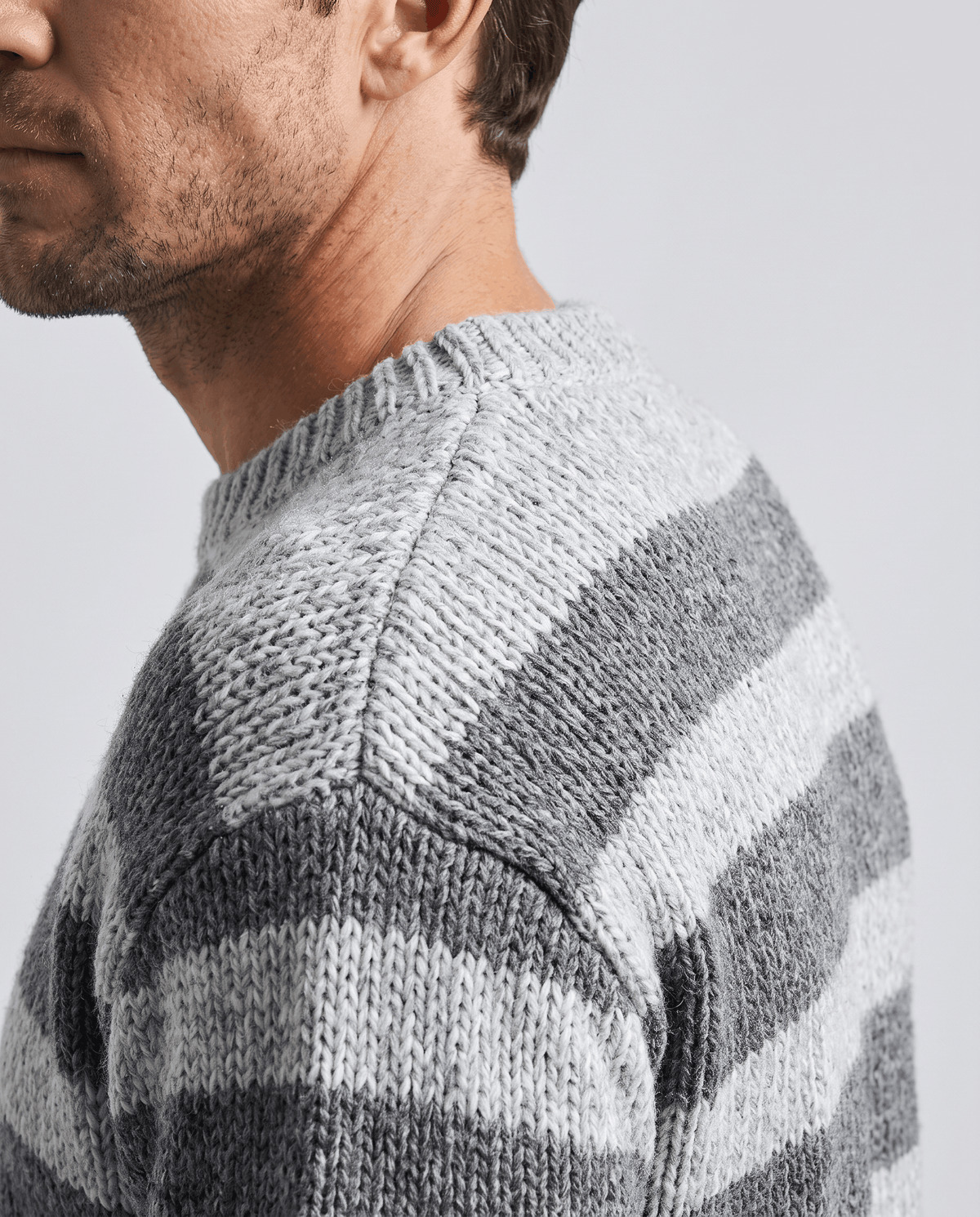 Side close-up of gray striped sweater at the collar and shoulder seam