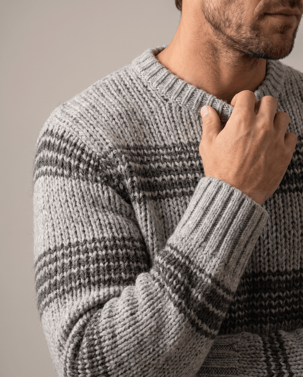 Close-up of gray marled sleeve with tonal stripes and ribbed cuff