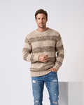 Man wearing men's striped chunky knit crew neck sweater in khaki with ripped jeans