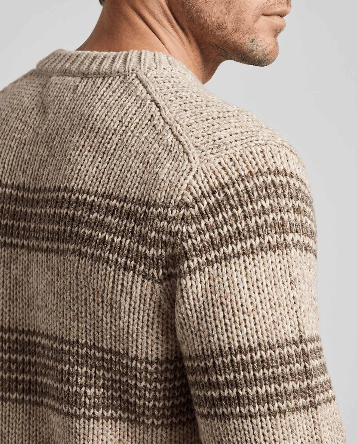 Back shoulder close-up of khaki sweater showing marled stripes and raglan seam