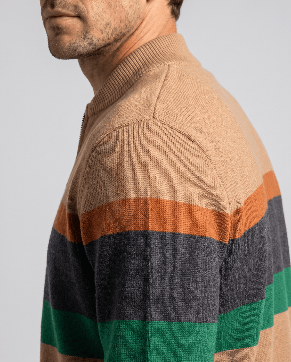 Side profile close-up of the beige knit with stand collar and orange, gray and green bands