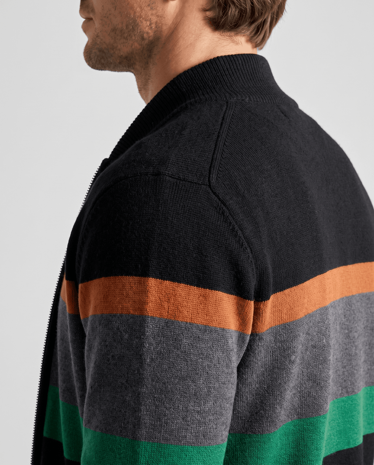 Side profile showing the stand collar and ribbed knit texture on the black and green cardigan