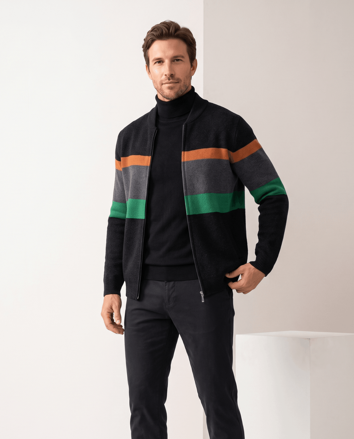 Man wearing a black striped full-zip cardigan sweater with orange, gray and green bands