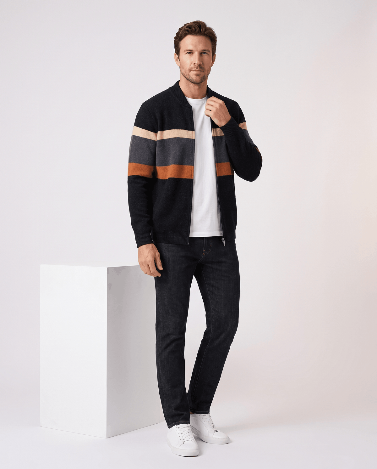 Full-length view of the black and orange cardigan styled with a white tee and black trousers