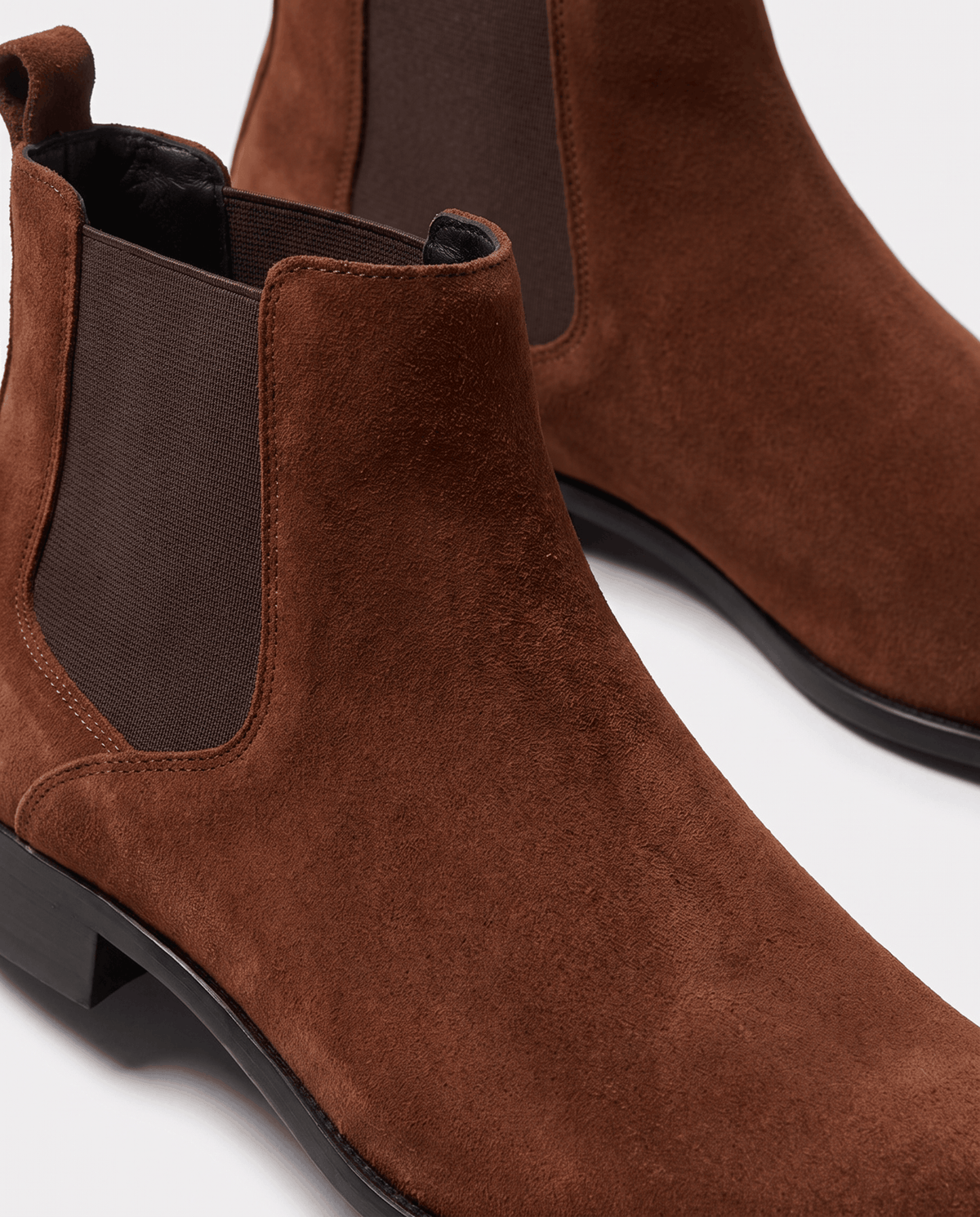 Close-up of brown suede nap and dark elastic side panel on a Chelsea boot