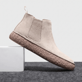 Beige Chelsea boot with a suede upper, elastic side panel, pull tab.