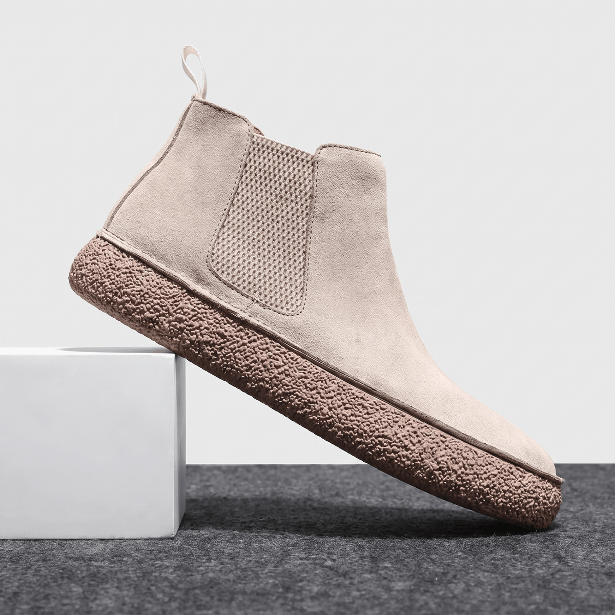 Beige Chelsea boot with a suede upper, elastic side panel, pull tab.
