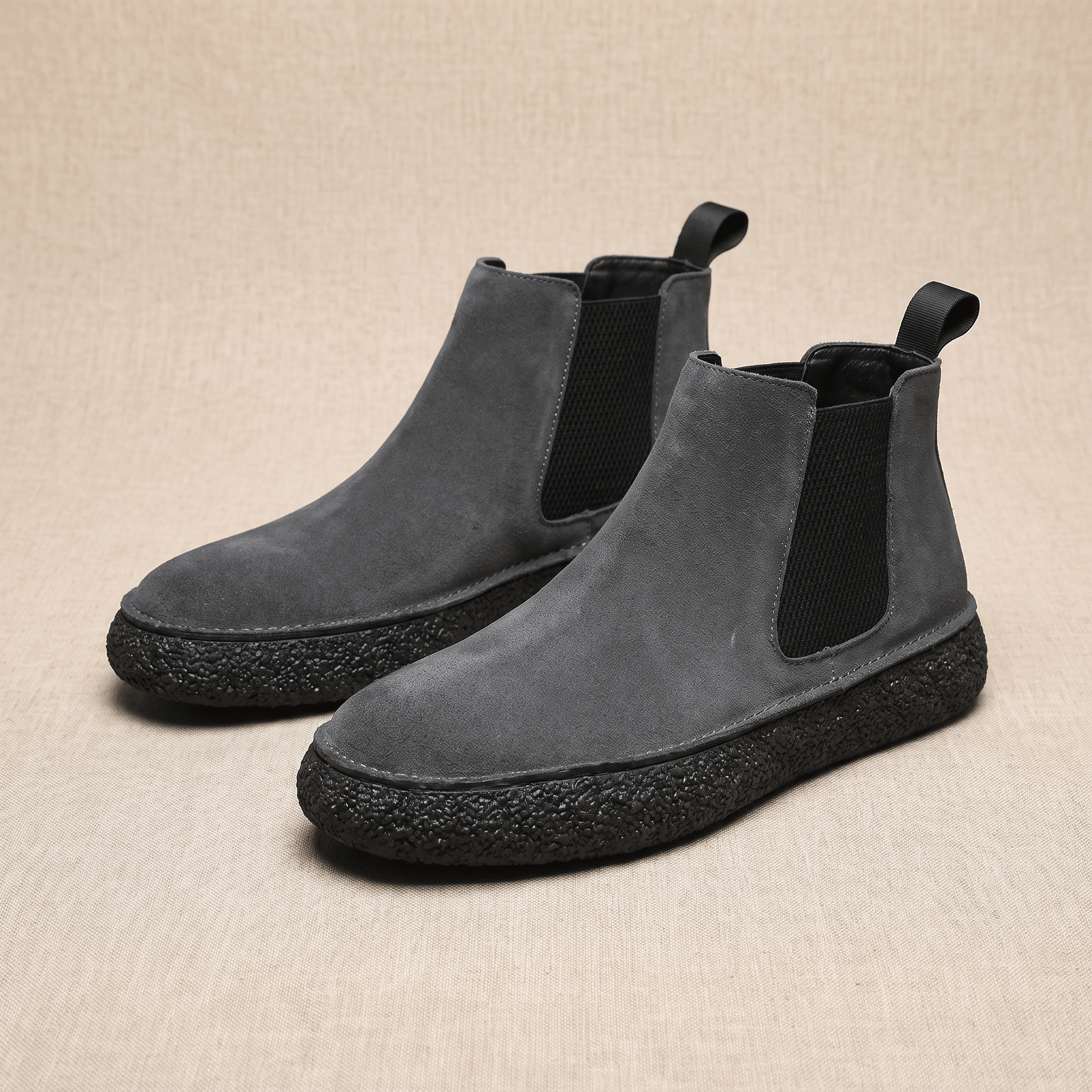 Pair of gray suede Chelsea boots featuring elastic side panels, pull tabs, and thick crepe soles.