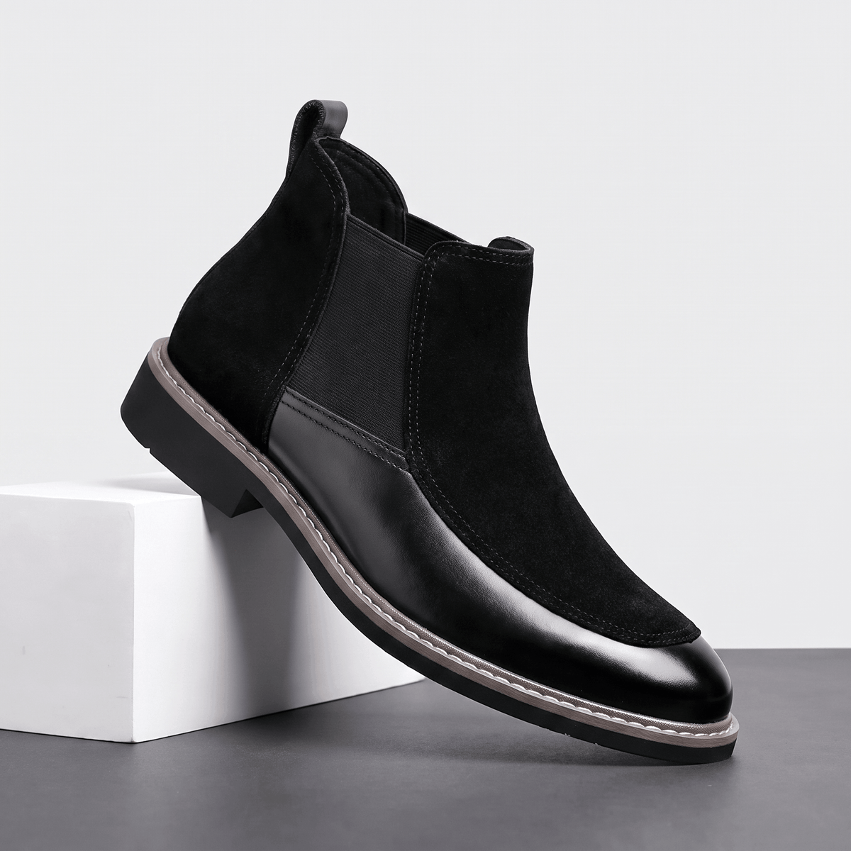 Black suede and polished leather Chelsea boot with elastic side gore, welt stitching, and a stacked heel.