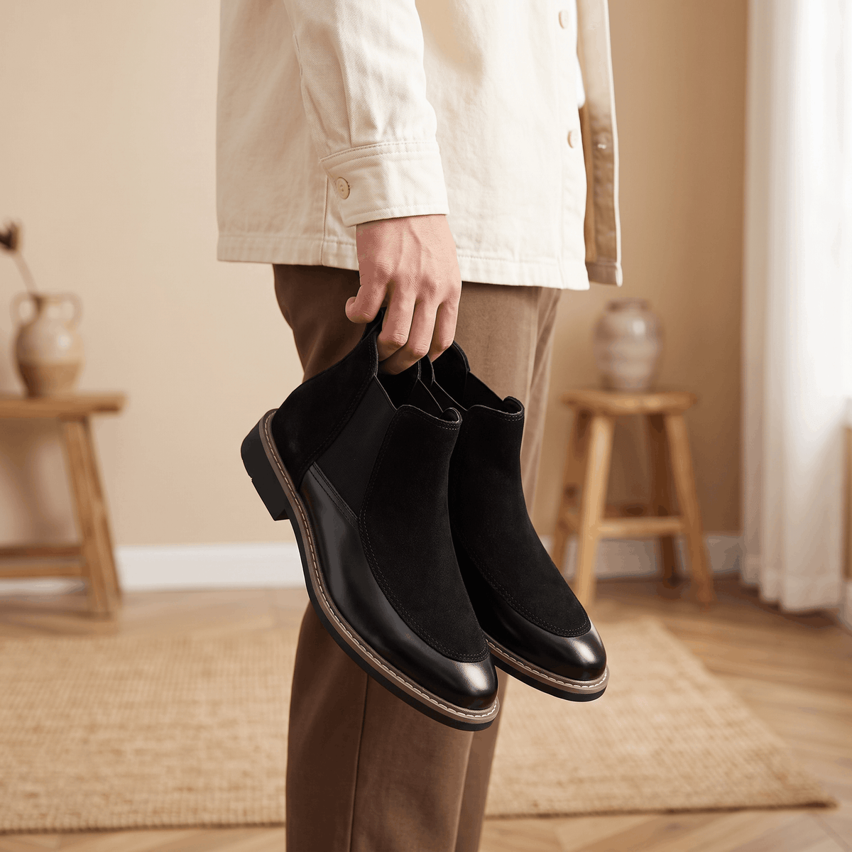 Black suede and polished leather Chelsea boots with elastic side gores, welt stitching, and a stacked heel.