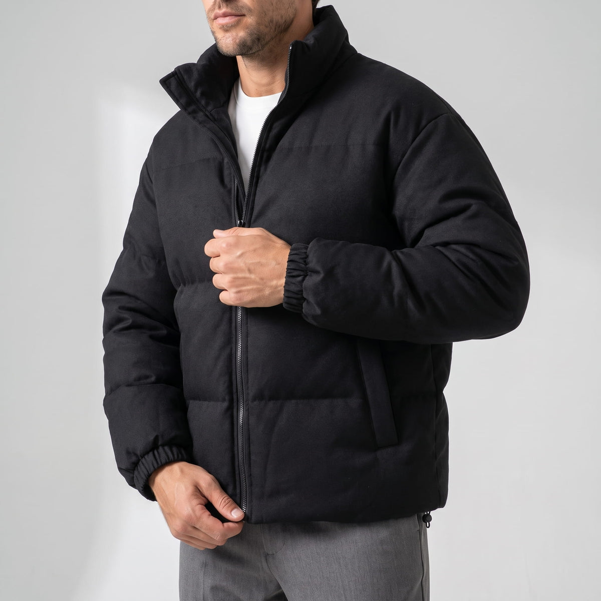 Black jacket worn open, showing the full-length zip and elasticated cuff