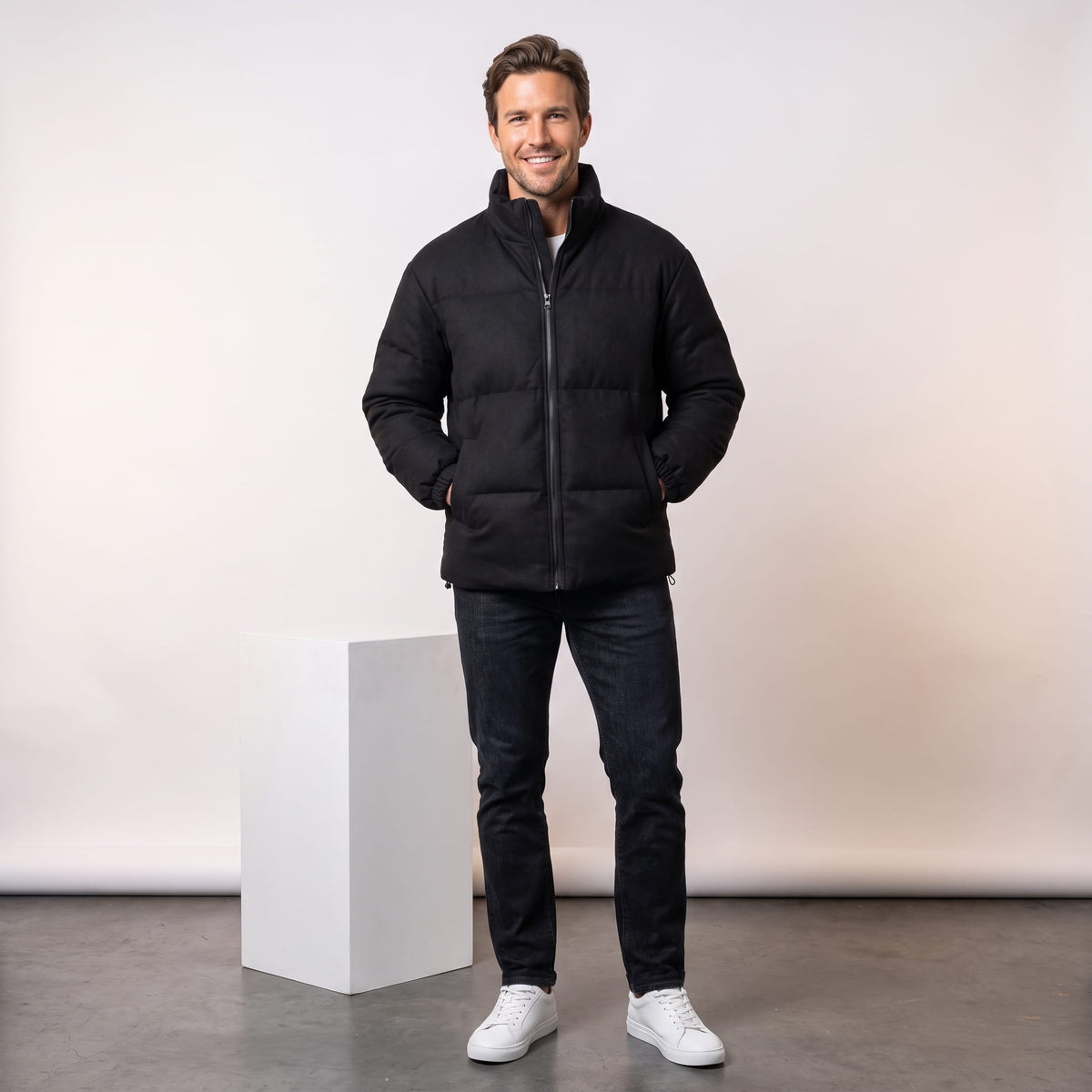 Black jacket styled full-length with dark jeans and white sneakers