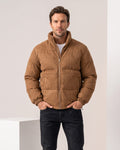 Man wearing brown suede-look puffer jacket with tall stand collar, hands in pockets