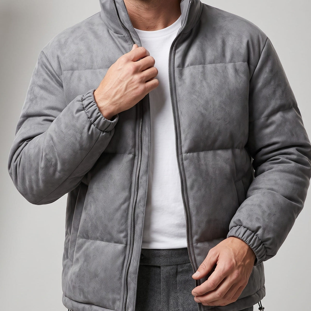 Gray jacket held open over a white tee, hand at the zip placket
