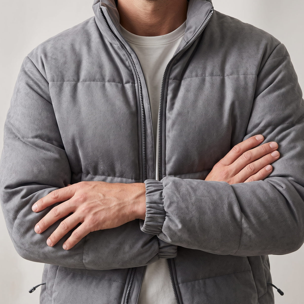 Gray torso with arms crossed, elasticated cuffs and quilted panels in view