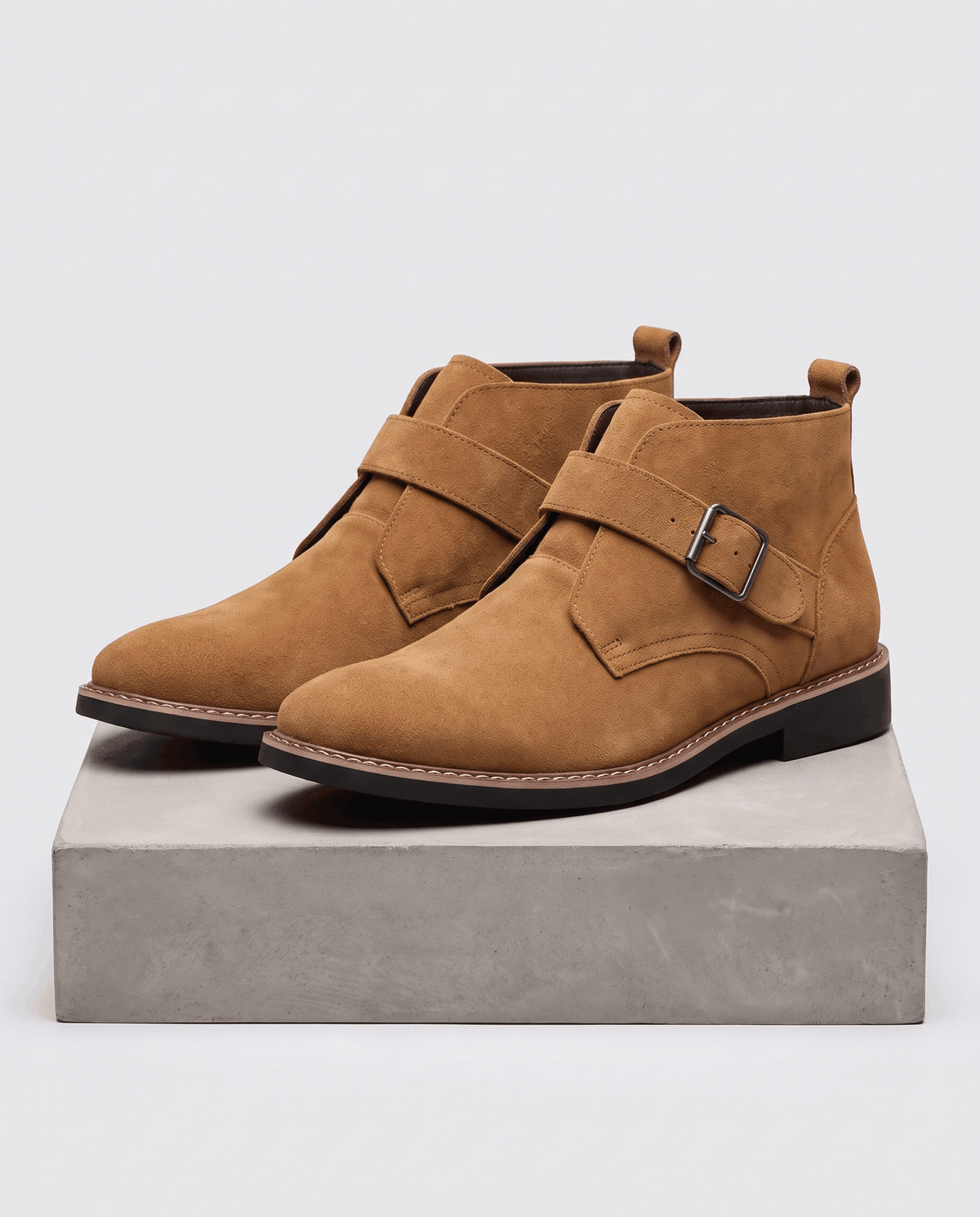 Men's suede monk strap boots in tan, shown as a pair on a stone block