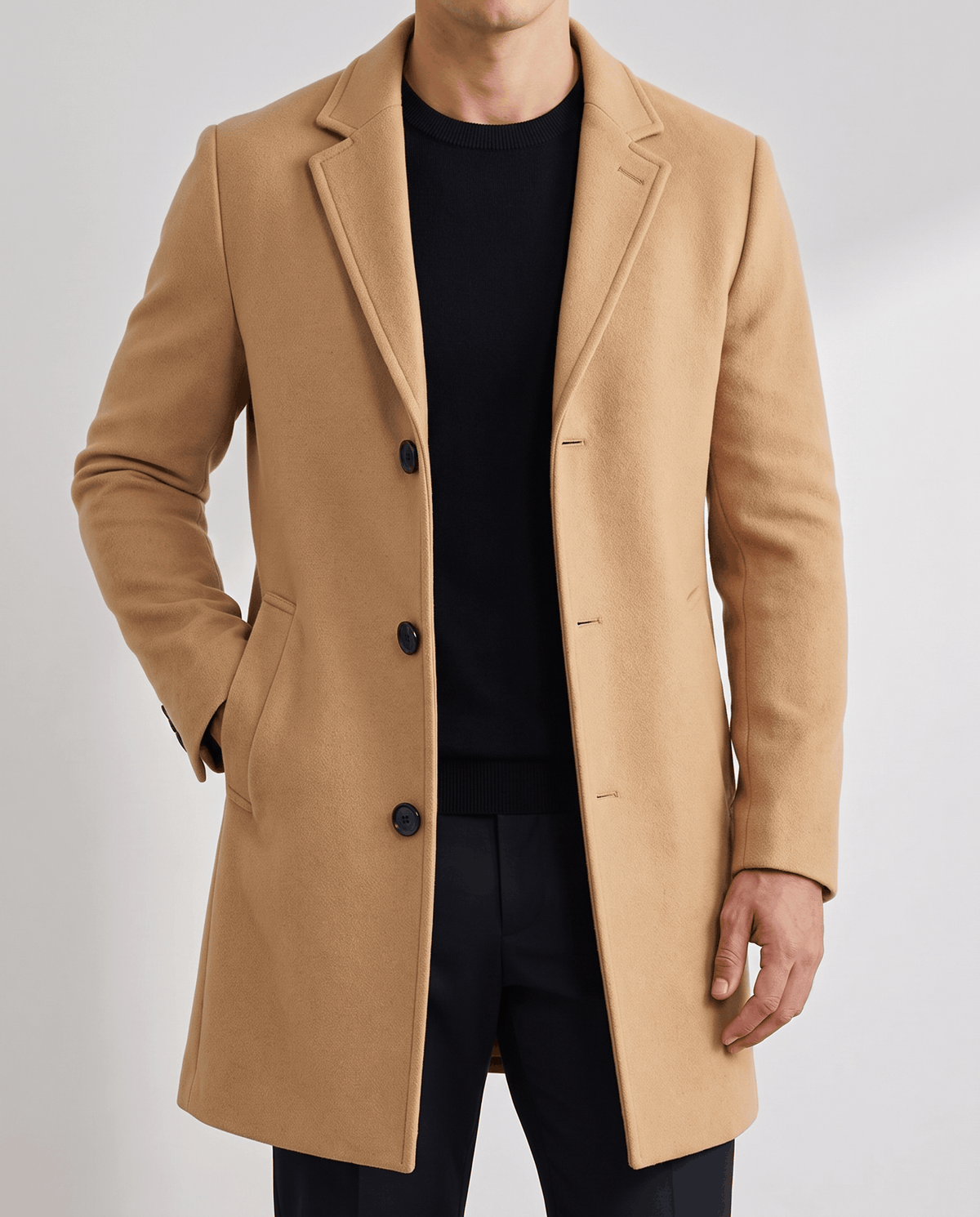 Khaki overcoat front detail with notch lapel and button front, worn over a black top