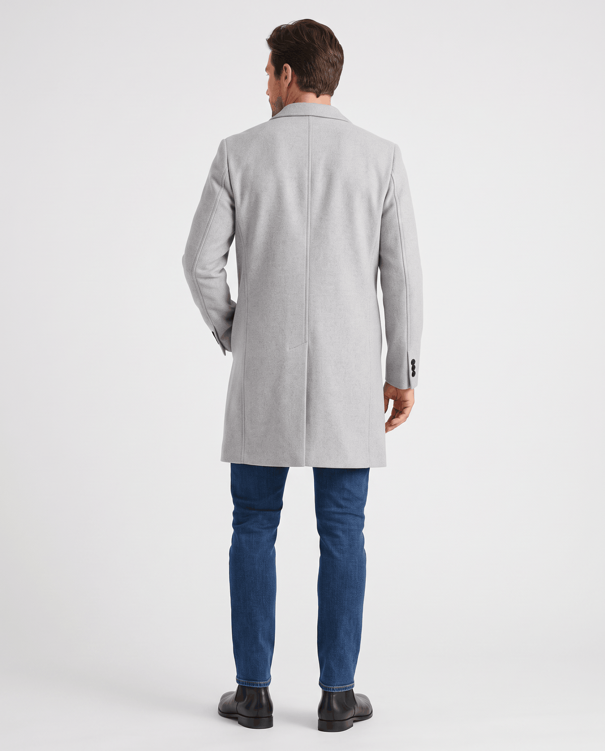 Back view of the light gray overcoat worn with dark trousers
