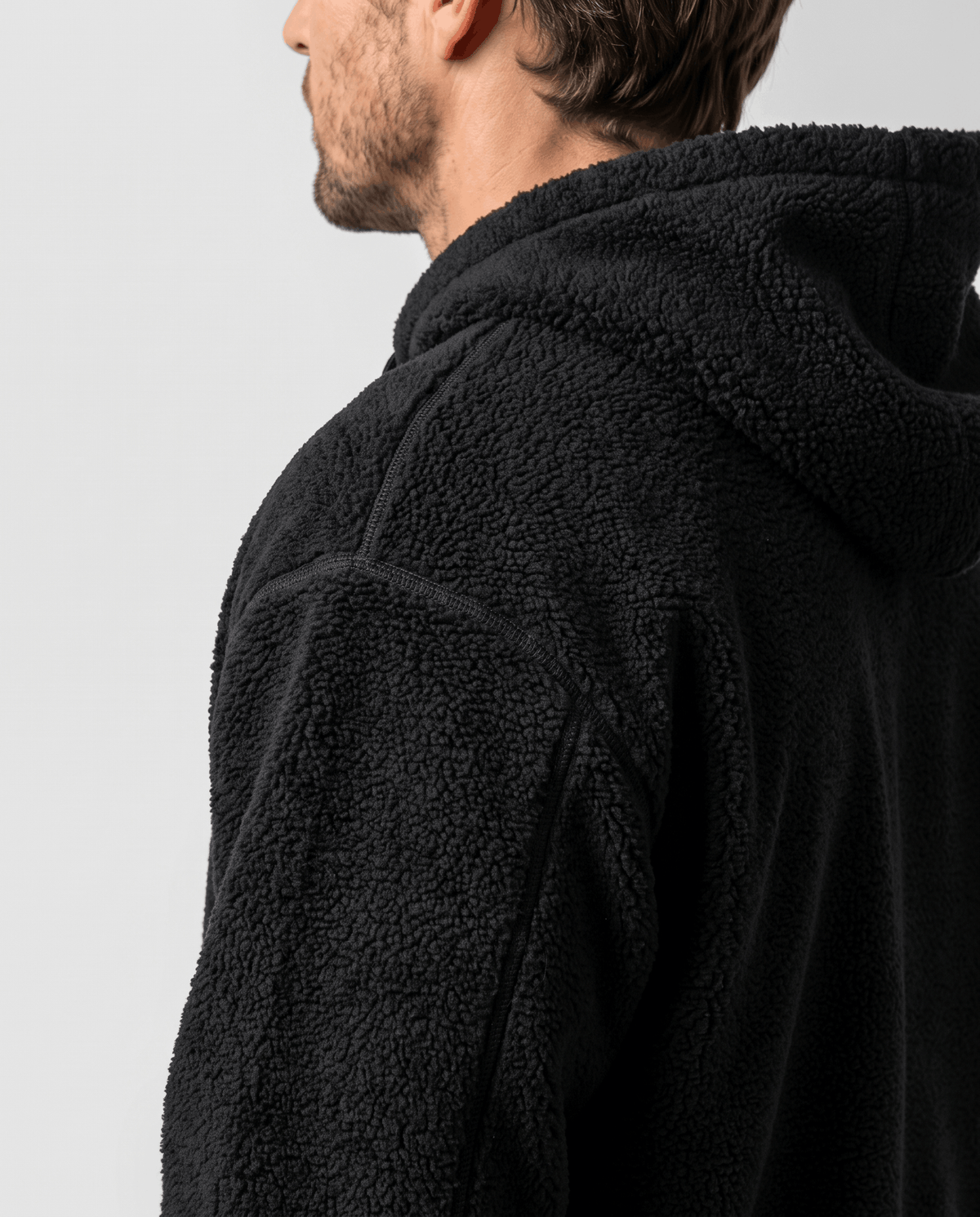 Close-up of black plush pile texture across shoulder and hood