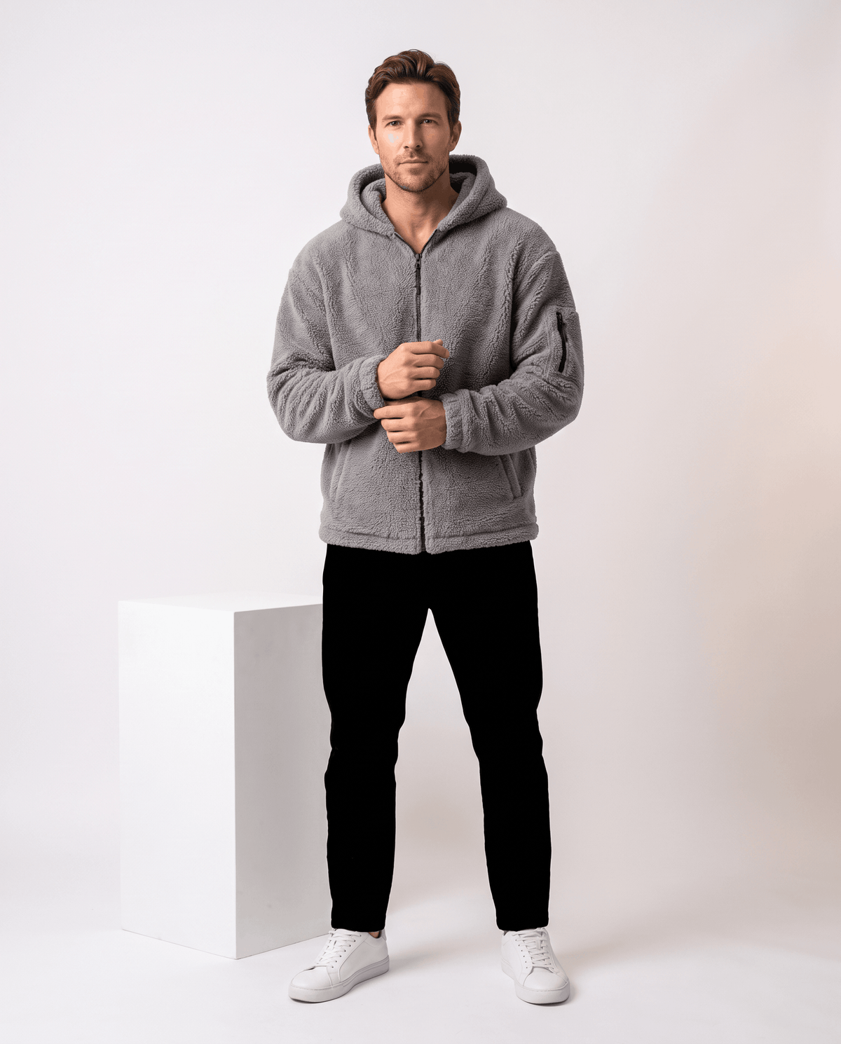 Full-length gray look with black pants and white sneakers in studio