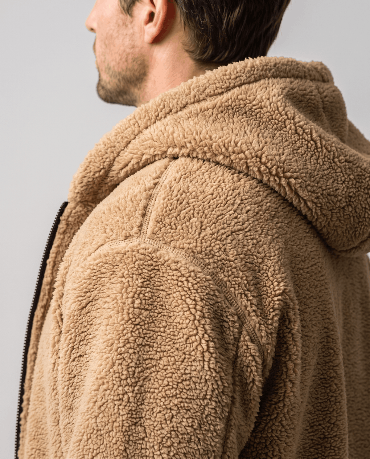 Side view of khaki plush pile shoulder and roomy attached hood