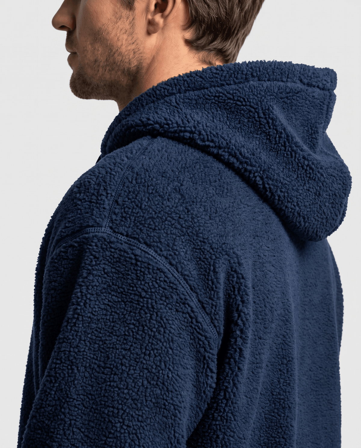 Side close-up of navy plush pile shoulder and generous hood