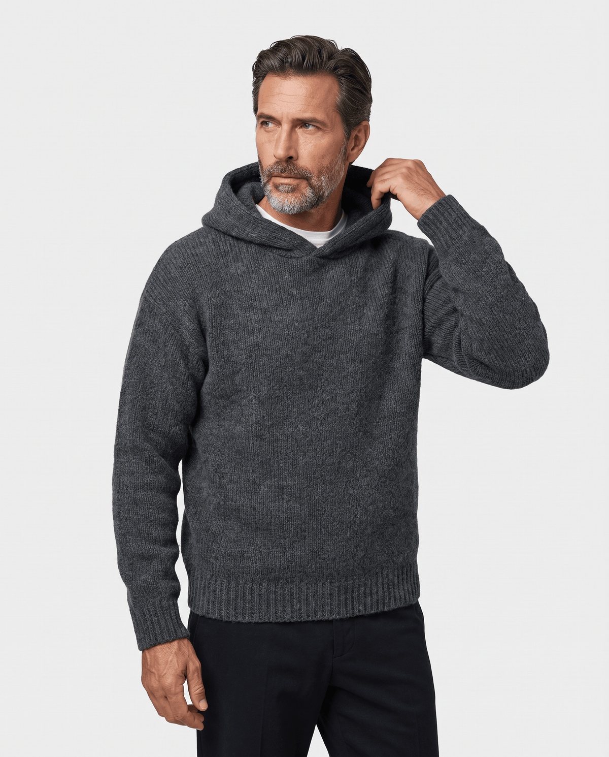 Dark gray knit pullover worn with the hood down, one hand at the collar, three-quarter view