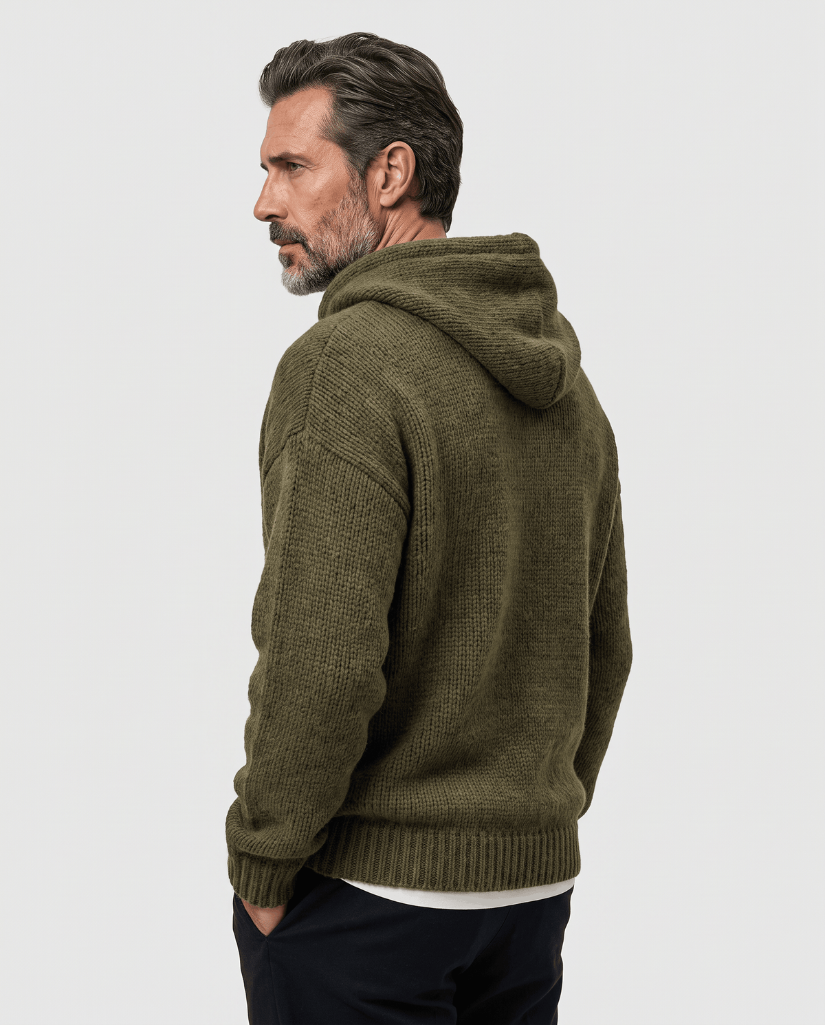 Side-back view of a green knit sweater with the hood down and hands in pockets
