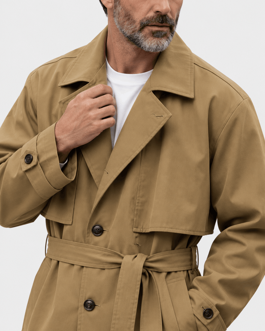 Close-up of the brown coat's notch collar, chest flap, tied belt and buttoned cuff