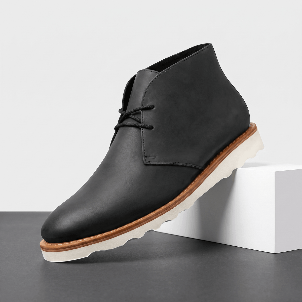 Black matte chukka boot with two-eyelet lacing, displayed on a white pedestal.