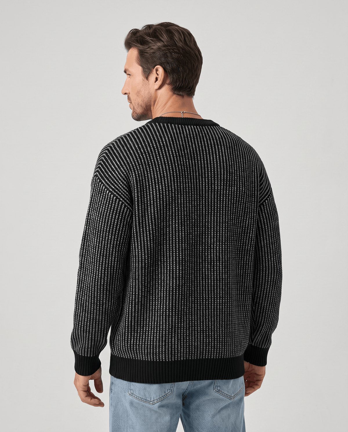 Back view of black two-tone knit pullover with solid ribbed hem