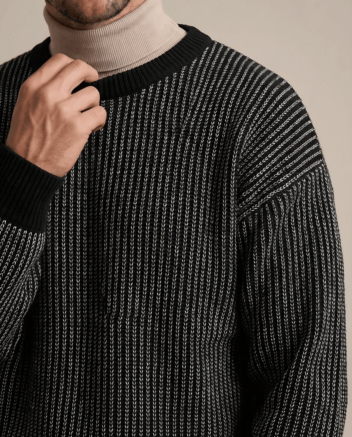 Close-up of hand at the black ribbed collar of a two-tone knit