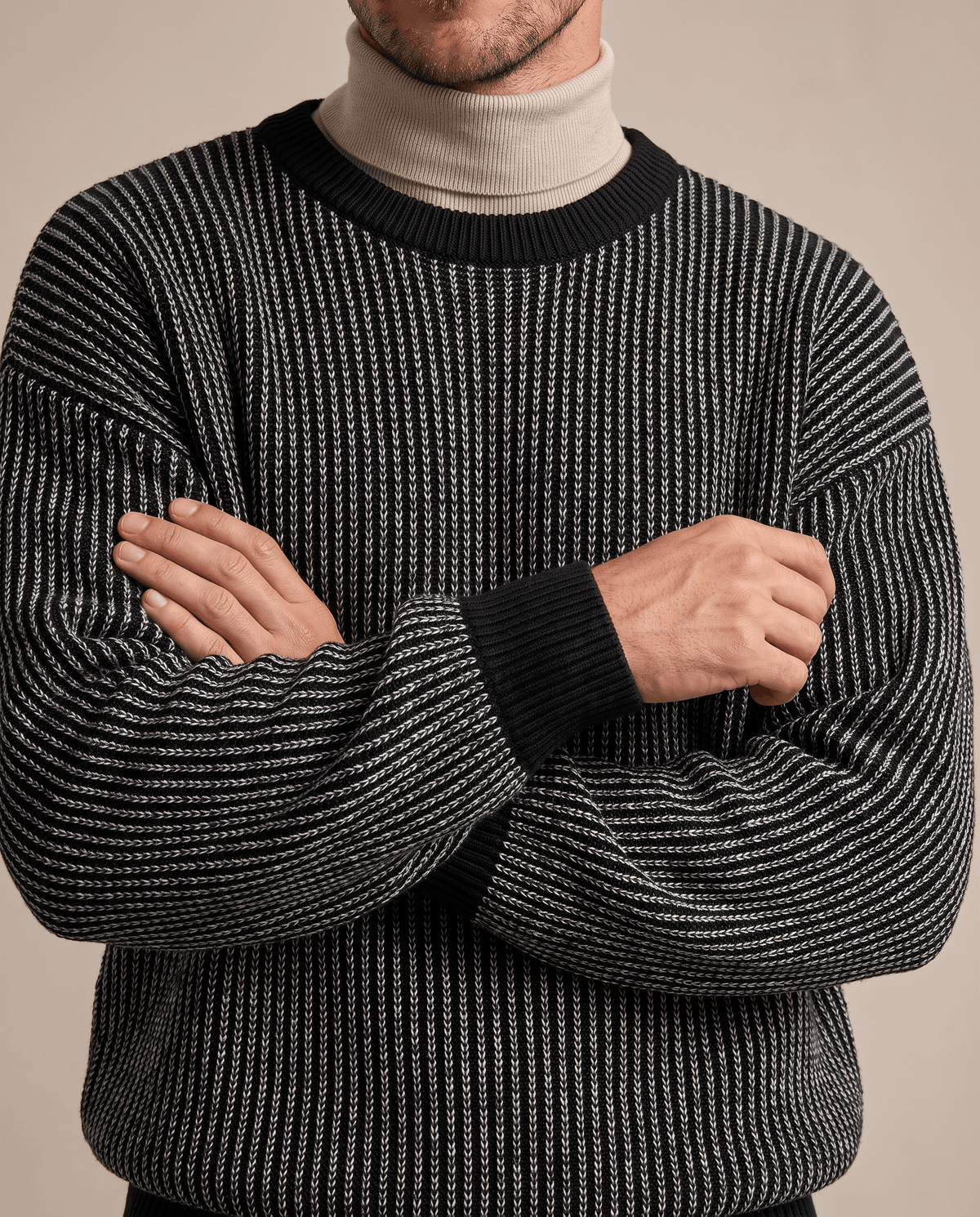 Black and gray striped knit over a beige mock neck with arms crossed