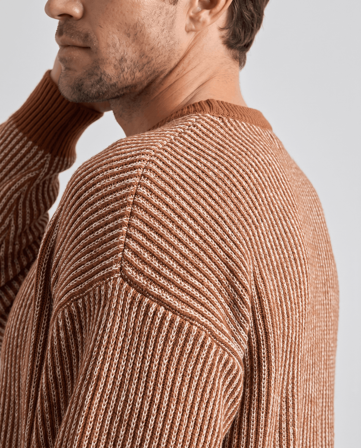Side close-up of brown sweater showing vertical rib stripes at the shoulder