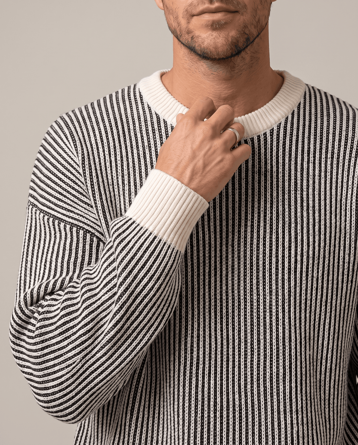 Close-up of hand at the cream ribbed collar of a striped knit