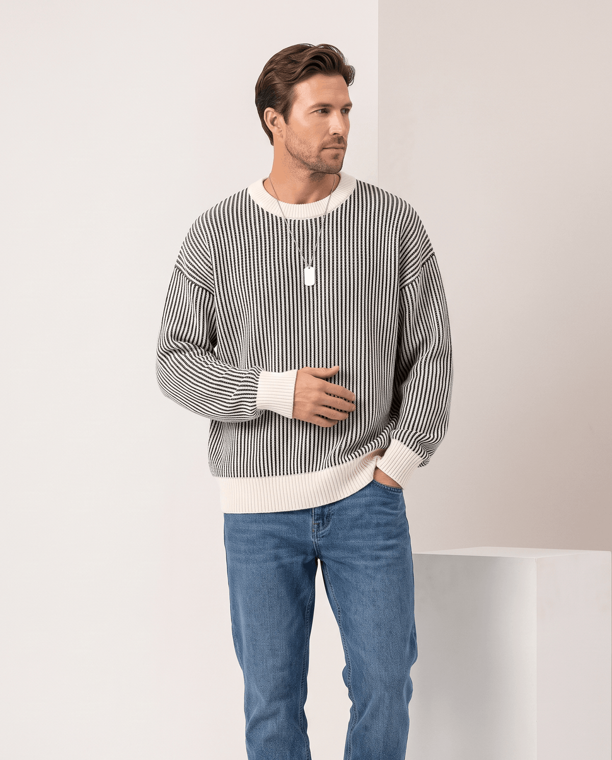 Model in black and cream striped sweater with cream trim and blue jeans