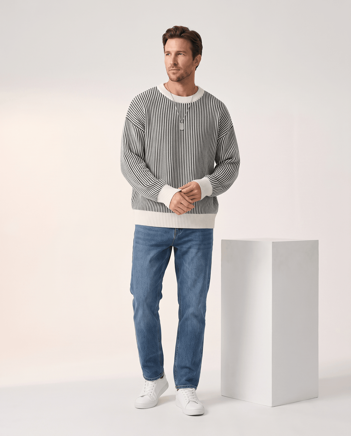 Full-length black and cream striped sweater look with jeans and sneakers