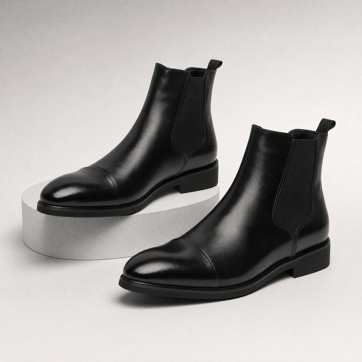Black vegan leather cap toe Chelsea boots with elastic side gussets, rear pull tabs, and a treaded rubber outsole.